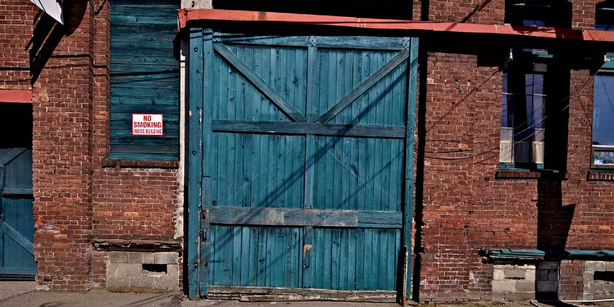 A blue barn door in a brick wall in the neighborhood