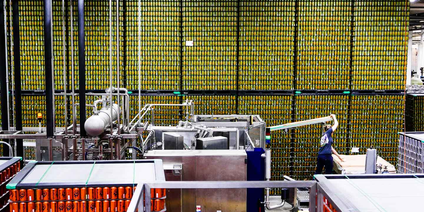 A wide shot of the canning area showing many rows and stacks of empty cans waiting to be filled