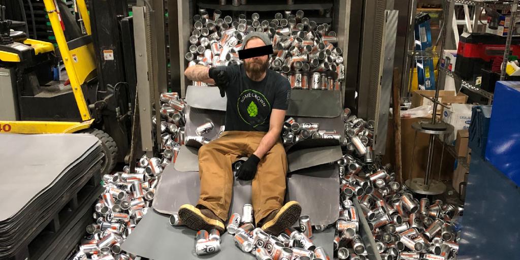 Brewer sitting on the ground surrounded by fallen beer cans